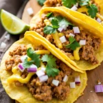 Three delicious buche tacos garnished with fresh cilantro, diced onions, and lime wedges.