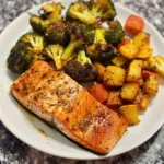 Cooked air fryer salmon and colorful vegetables on a plate