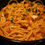 CrockPot chicken spaghetti dish garnished with herbs and served in a bowl
