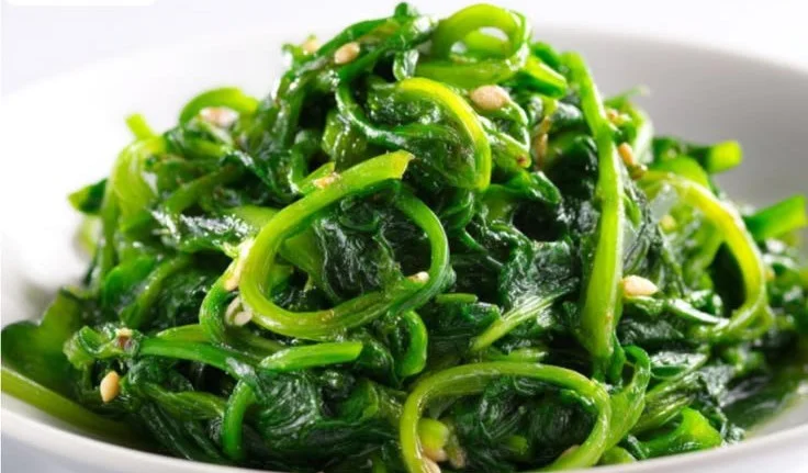 Bowl of Korean Spinach Salad (Sigeumchi Namul) garnished with sesame seeds