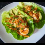 Avocado shrimp lettuce wraps with peanut sauce served on a plate