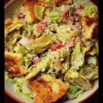 Chopped sub salad topped with crispy artichokes served in a bowl.
