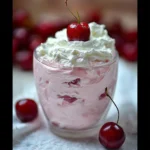 Bowl of easy cherry fluff dessert topped with cherries and whipped cream