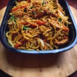 Bowl of macro friendly high protein chicken chow mein with colorful vegetables