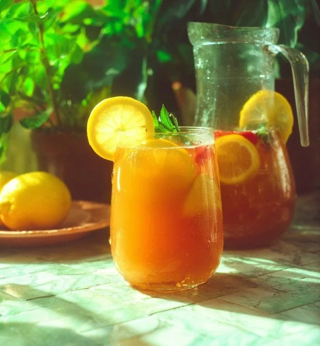 A colorful glass of summer punch with fruits and ice, perfect for hot days.